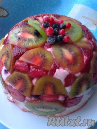 Накрыть миску и поставить в холодильник до полного застывания (примерно на 2-3 часа). Фруктово-бисквитный торт готов. Вынуть миску из холодильника, перевернуть торт на блюдо и снять плёнку (у меня плёнки не было и, чтобы достать торт, я опустила посуду с тортом в кипяток на пару секунд). Сверху украсить торт ягодами и фруктами на ваш вкус.