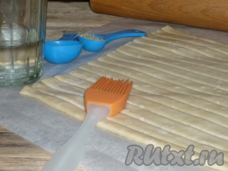 Смазать полоски теста водой, посыпать кунжутом, я ещё присыпала тмином.