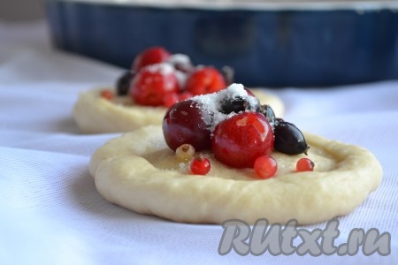 Из такого дрожжевого теста можно испечь просто пышные булочки без начинки или булочки со сладкой начинкой. Я выбрала второй вариант. Ягоды вымыть, выложить на салфетку, чтобы избавиться от лишней влаги. Подошедшее тесто обмять. Тесто скатать в валик и нарезать на равные части по количеству будущих булочек. Если будете печь булочки без начинки, то просто скатайте каждую часть теста в шар. Если будете готовить с начинкой, тогда каждую часть теста нужно слегка раскатать скалкой в лепёшку, в центр выложить ягоды  (или кусочки фруктов) и присыпать начинку сверху сахаром (количество сахара регулируйте по вкусу, исходя из сладости ягод или фруктов).