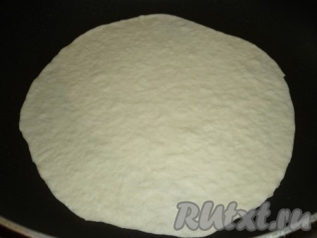 Сковороду хорошо разогреть, выложить круг из теста и жарить тонкий домашний лаваш на среднем огне с двух сторон до появления коричневых пятен.