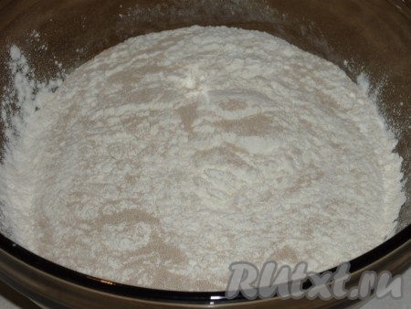 В глубокую миску всыпать просеянную муку, добавить дрожжи, сахар, соль и перемешать.