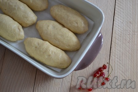 Выложить все подготовленные заготовки пирожков в форму, застеленную пекарской бумагой. Выкладываем&nbsp;швом вниз. Накрыть пирожки полотенцем и оставить минут на 20 для подъёма.