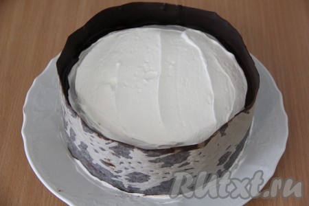 Готовый торт украсить по желанию. Я сделала бордюр из шоколада. Для этого: растопить шоколад на водяной бане, затем нанести шоколад на полоску из пергаментной бумаги. Ширину и высоту бортика измерить по торту. Приставить полоску пергамента шоколадной стороной к торту и аккуратно прижать. Поставить торт в холодильник на 15-20 минут, для того чтобы шоколад застыл.