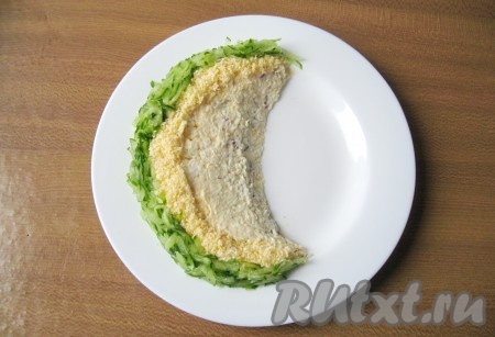 Огурец помойте и натрите на крупной терке. Выложите зелёную часть "арбуза".
