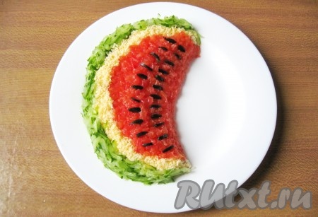 Возьмите 2-3 маслины и нарежьте их тоненькими полосками.  Выложите полоски маслин в мякоти арбуза в виде семечек.
