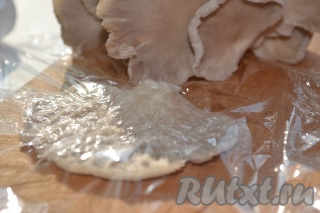 Разделить гроздья вешенок на отдельные грибы. Накрыть каждый гриб пищевой плёнкой.