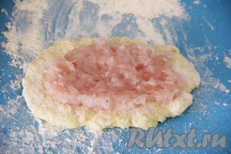 Рабочую поверхность присыпать мукой, выложить часть картофельной массы (я зрительно разделила картофельную массу на 10 частей и соответственно формировала 10 зраз) и распределить в ровный пласт в виде лепёшки. На картофельную лепёшку выложить часть фарша (фарш я тоже зрительно разделила на 10 частей). Разровнять фарш, оставляя края картофельной лепёшки чистыми.