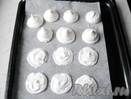 С помощью кондитерского мешка отсадить взбитые белки с сахаром на противень с бумагой для выпечки. Половина белковой массы должна быть в виде плоских лепешек, а половина в виде башенок. Плоские безе будут основой пирожных, а башенки - его верхом.
