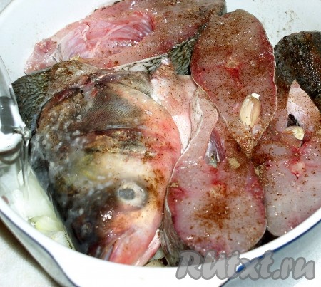 Рыбу нарезать порционными кусками, слегка присолить и обтереть солью со всех сторон, но только слегка. Уложить плотно на дно кастрюли, присолить сверху и посыпать молотым мускатным орехом. В каждый кусочек воткнуть дольку чеснока в шелухе, а большой зубчик положить внутрь головы. Полить всю поверхность рыбы растительным маслом. Осторожно влить под край немного холодной воды.
