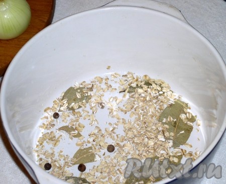 На дно кастрюльки выложить лавровый лист, горошины душистого перца (по желанию) и ложечку овсяных хлопьев. Они предназначены для впитывания сока и создания вкусной эластичной подливки. Правда, попадаются разные по качеству хлопья и не каждый раз они превращаются в однообразный соус. Впрочем, можно обойтись и без хлопьев.
