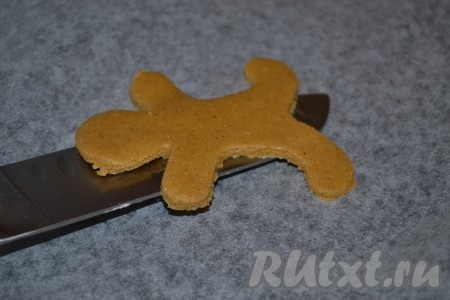 Аккуратно, помогая ножом, переложить фигурки на застеленный бумагой для выпечки противень. Выпекать имбирное печенье в разогретой до 180 градусов духовке 15 минут.
