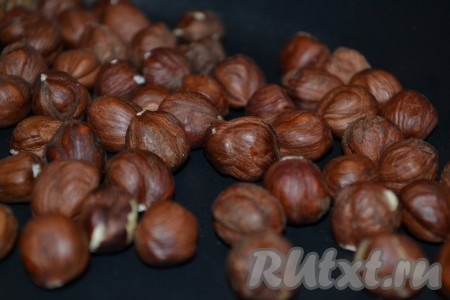 Фундук выложить на толстостенную сковороду, поставить на огонь и обжарить, периодически помешивая, в течение 10-15 минут. Затем со сковороды переложить на полотенце, завернуть в него и потереть орехи друг о друга, чтобы избавиться от шелухи. 
