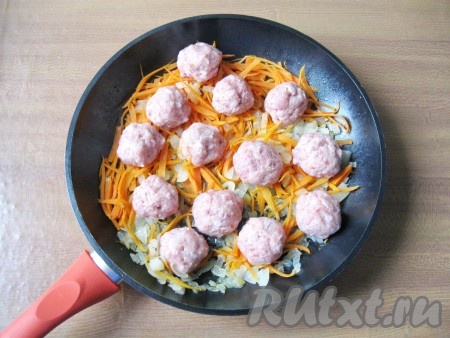 Из фарша влажными руками сформировать фрикадельки размером чуть больше грецкого ореха. Выложить фрикадельки на сковороду с обжаренными луком и морковью.