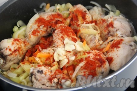 Затем перемешать курицу с овощами. Чеснок нарезать на тонкие лепестки (можно пропустить через пресс или просто раздавить зубчики ножом). Добавить паприку и чеснок в сковороду, слегка посолить, хорошо перемешать, влить немного воды или бульона. Убавить огонь, накрыть сковороду крышкой и тушить кусочки курочки, примерно, 30 минут, периодически помешивая. Следите, чтобы блюдо не пригорело.