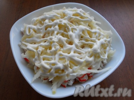 Следующий слой - очищенное от кожуры и семечек, а затем натёртое на крупной тёрке яблоко, немного смазать майонезом.
