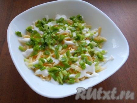 Зелёный лук вымыть, обсушить, мелко нарезать, выложить следующим слоем салата.