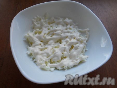 Крабовые палочки разморозить при комнатной температуре. Яйца сварить вкрутую (в течение 10 минут после начала кипения воды), остудить, очистить, отделить белки от желтков. Салат выкладывается в салатник слоями. Первым слоем выложить натёртые на крупной тёрке яичные белки, немного посолить, нанести сеточку из майонеза.