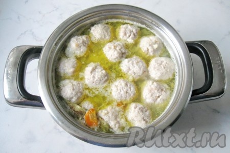 После того как морковка с луком проварятся 10 минут, добавить в суп пшено и варить ещё 10 минут. Затем в суп с пшеном выложить подготовленные рыбные фрикадельки. Добавить лавровый лист, соль и чёрный молотый перец по вкусу, дать закипеть, варить суп на небольшом огне ещё 10-15 минут (до готовности пшена).