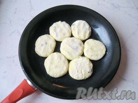 Заранее разогреть сковороду с растительным маслом. Из получившегося творожного теста влажными руками сформировать сырники. Каждый сырник обвалять в муке со всех сторон. Всего у меня из 400 грамм творога получилось 13 сырников небольшого размера. Выложить заготовки сырников на разогретую сковороду и жарить 2-3 минуты (до румяной корочки снизу) на среднем огне.