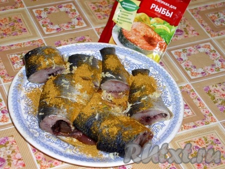 Нарезать на порционные кусочки (у меня была крупная сельдь, поэтому я каждую рыбу разрезала на 4 части), натереть сверху чесноком, посыпать специями и перемазать этим "маринадом" все кусочки сельди. 
