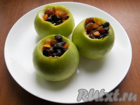 Изюм (я использовала разные сорта изюма) желательно предварительно залить кипятком на 5 минут, затем лишнюю воду слить. У меня ещё было несколько штук кураги и чернослива, я их промыла, мелко нарезала и смешала с изюмом, но можно обойтись и только одним изюмом. Наполнить углубления в яблоках подготовленным изюмом.