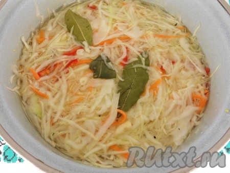 Капусту с овощами и специями хорошенько перемешать. Приготовить маринад: в кастрюлю влить воду, добавить соль и сахар. Поставить кастрюлю на огонь и довести маринад до кипения. Влить уксус и добавить лавровый лист. Кипятить маринад минуты 3, после чего сразу же залить им подготовленную капусту.
