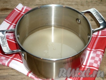 В кастрюлю насыпать сахар, влить 140 миллилитров воды, поставить на средний огонь.