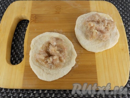 Тесто скатать колбаской и нарезать на небольшие кусочки. Каждый кусочек раскатать в небольшую лепёшку (не слишком тонко, но и не толсто). В центр каждой лепёшки поместить 1 столовую ложку фарша.