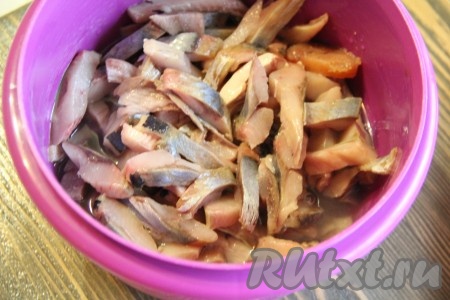 Выложить кусочки селёдки в глубокую тару и залить уксусом. Уксус должен полностью покрыть селёдку. Прижать кусочки сельди блюдцем, сверху поставить небольшой гнёт (например, чашку с водой). Оставить сельдь в таком виде на 30 минут.