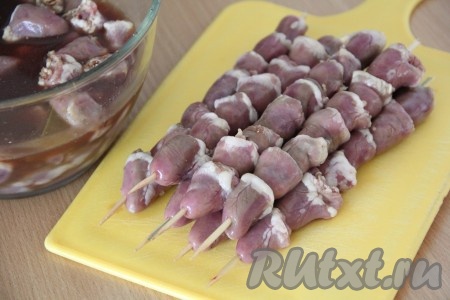Замаринованные куриные сердечки достать из маринада и нанизать на деревянные шпажки. Я предварительно замочила шпажки в холодной воде, буквально на 30 минут.