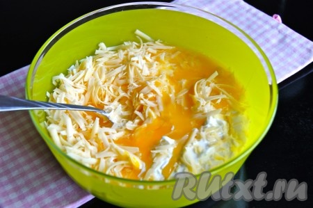 Сливочное масло растопить на плите (или в микроволновке), дать ему немного остыть. Для замешивания теста для оладий нужно в объёмную миску выложить сметану, добавить натёртый на крупной тёрке сыр, сырые яйца, растопленное и чуть остывшее сливочное масло, натёртый на мелкой тёрке чеснок и хорошенько перемешать. Если не любите чеснок, то можете его не добавлять.