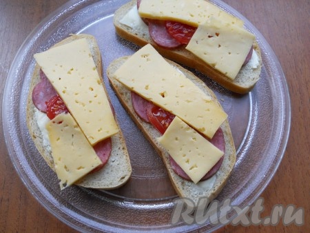 Далее - по 1-2 кружочка помидора, нарезанных острым ножом (маринованные помидоры должны быть твердыми). И сверху накрыть все тонкими ломтиками твердого сыра.
