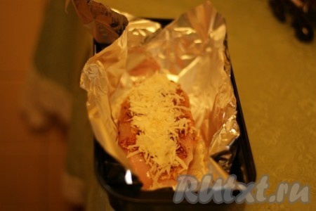 Форму для выпекания застелить фольгой, выложить в нее курицу и присыпать сыром.