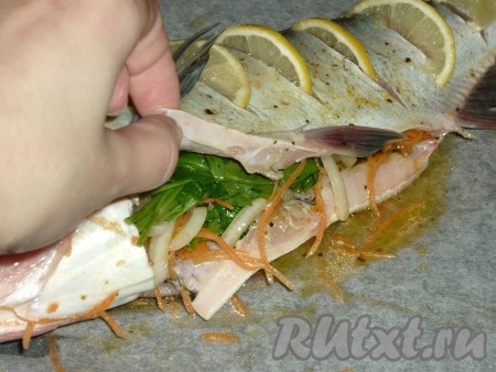 Противень застелить пергаментом, выложить толстолобика. Хорошо смазать толстолобика внутри и снаружи частью получившейся масляно-лимонной смеси. Оставшуюся масляно-лимонную смесь перемешать с морковью, луком и петрушкой, нафаршировать ими брюхо рыбы. В надрезы сверху вставить кусочки лимона.&nbsp;