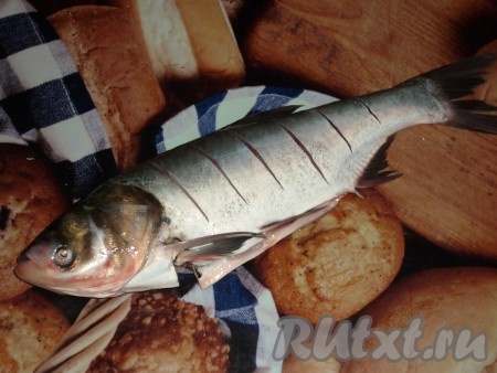 Толстолобика очистить от чешуи, удалить жабры. Разрезать брюшко, удалить из него внутренности. Тщательно промыть рыбу. Сделать на рыбе надрезы (расстояние между надрезами примерно 3-4 сантиметра).&nbsp;