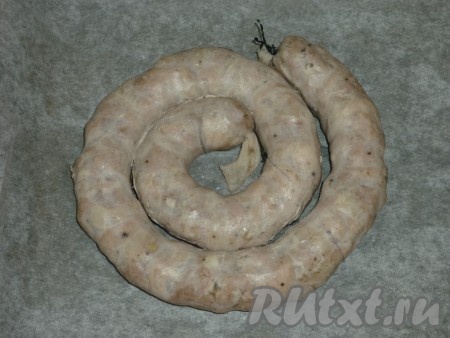 Противень застелить пергаментом и выложить колбасу. Сверху слегка смазать её растительным маслом или смальцем. 