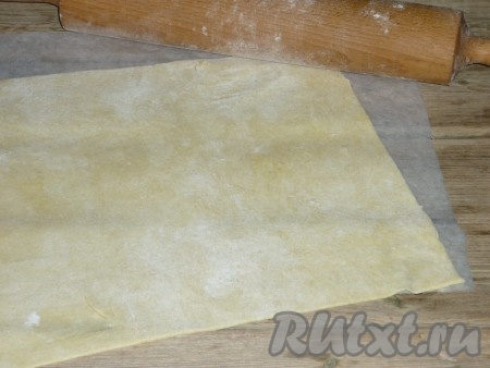 Тесто достать из холодильника и разделить на 2 части. На столе, присыпанном мукой, раскатать каждую часть теста в тонкий пласт,&nbsp;толщиной примерно 3 мм.
