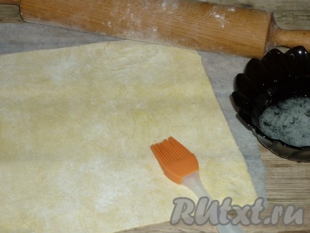 Яичный белок слегка взбить вилкой. Пласт теста смазать яичным белком с помощью силиконовой кисточки.&nbsp;
