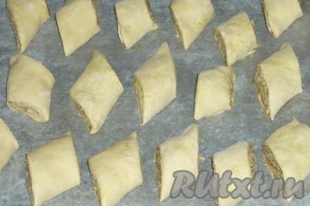 Противень застелить пергаментом, духовку разогреть до 180 градусов. Выложить рулетики на противень, смазать верх яичным белком и отправить выпекаться в духовку на 35-40 минут.&nbsp;
