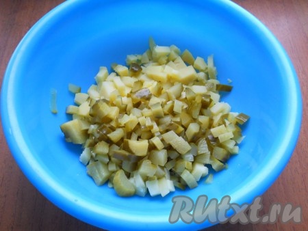 Картофель, сваренный в кожуре, остудить и очистить. Отварить, остудить и очистить яйца. Нарезать картофель небольшими кубиками, добавить также нарезанные маринованные огурцы.
