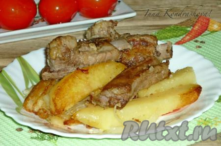 Готовые свиные рёбрышки с картошкой переложить со сковороды на тарелку и подать к столу в горячем виде, дополнив, по желанию, свежими или солёными овощами.