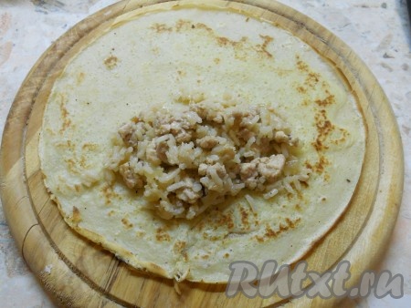 Блинчики пожарить обычным способом. Для первого блина сковороду смазать растительным маслом, следующие блины можно жарить на сухой сковороде. Далее на каждый блинчик выкладывать по 1-2 столовой ложке начинки из риса и мяса.
