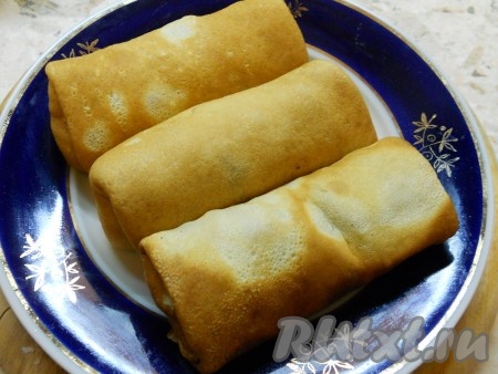 Блинчики свернуть конвертиками или трубочками, загибая обязательно края.
