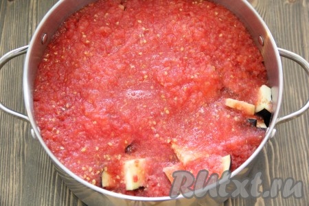 Помидоры вымыть, а затем пропустить через мясорубку. Добавить измельчённые помидоры в кастрюлю к баклажанам.
