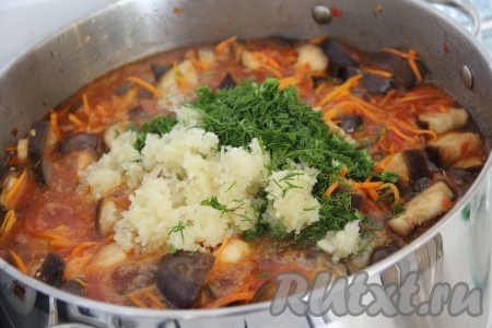 За пять минут до готовности салата добавить в кастрюлю измельчённый чеснок и укроп. Всё тщательно перемешать, дать салату из баклажанов с помидорами и морковью покипеть 3-5 минут, а затем снять с огня.
