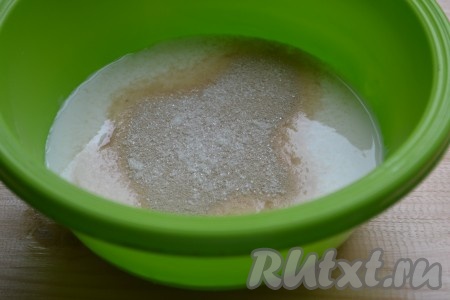 Кефир для замешивания теста должен быть тёплым (примерно 38-40 градусов), я подогреваю его в течение 30 секунд в микроволновке, можно просто достать заранее из холодильника. Вливаем в миску тёплый кефир, добавляем дрожжи, сахар, 2 столовых ложки пшеничной муки от общего количества, тщательно перемешиваем, накрываем миску полотенцем и убираем в тёплое место минут на 20.