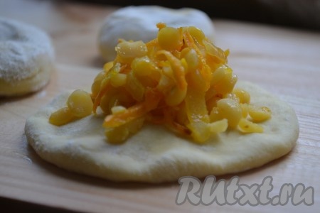 Готовое тесто обминаем и делим на равные кусочки. Раскатываем каждый кусочек теста в нетонкую лепёшку, на середину выкладываем часть начинки.