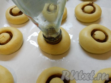 Слегка вдавливать горлышко бутылки в шарики из теста, каждый раз снова окуная горлышко в какао.