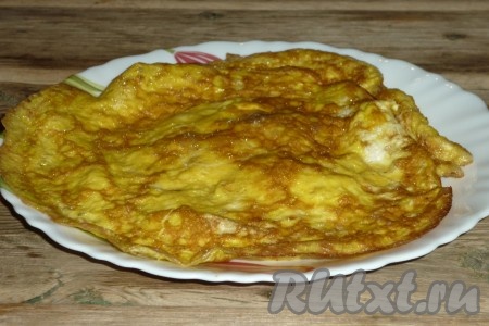 Таким же образом сделать ещё два блинчика из яиц. В результате должно получится три блина. Их нужно сложить в стопку, свернуть рулетом и нарезать полосками шириной в сантиметр.&nbsp;
