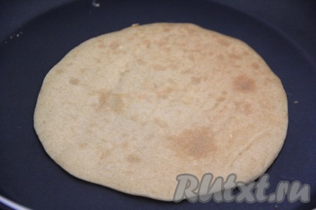 Жарить блин на среднем огне с двух сторон до золотистого цвета, затем переложить на тарелку. Периодически перемешивая тесто, постепенно пожарить все блины.